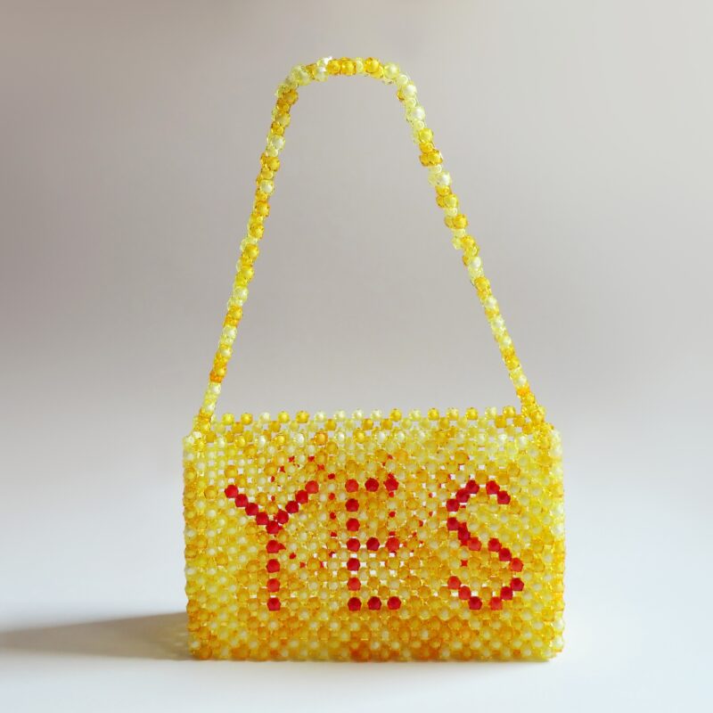 żółta torebka z koralików z czerwonym napisem YES (tak)